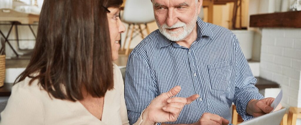 An image showing a senior couple looking worried while reviewing their finances, representing the retirement planning mistakes to avoid when preparing for unexpected expenses in retirement.