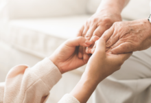 Elderly person holding hands with a child