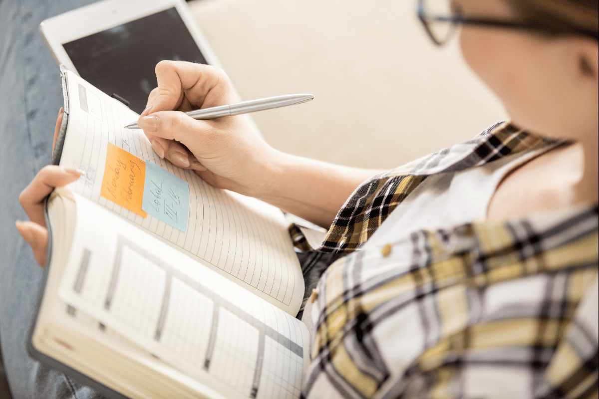 Person writing their long-term goals in a planner