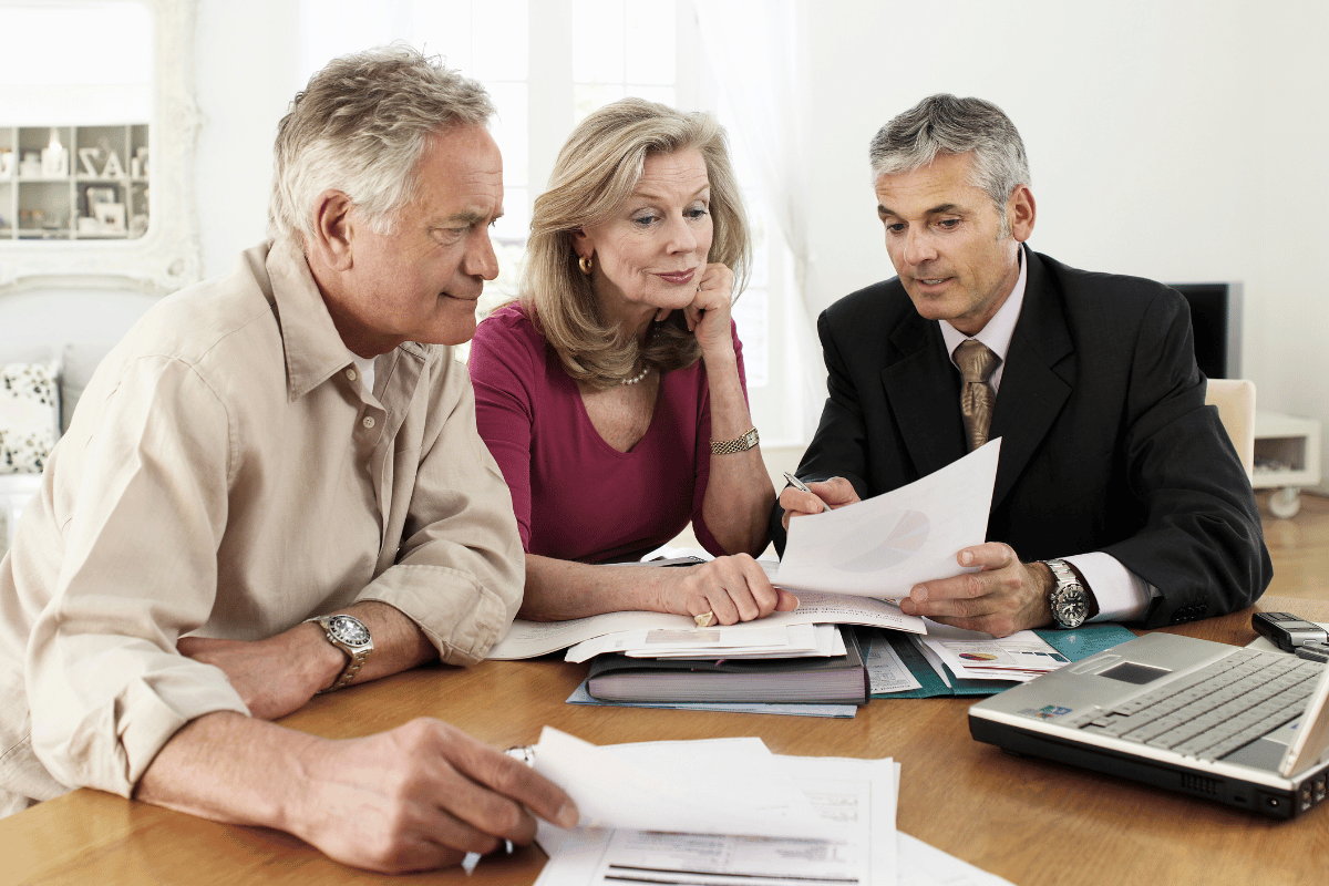 Older couple sitting at a table seeking legal and tax advice from a consultant