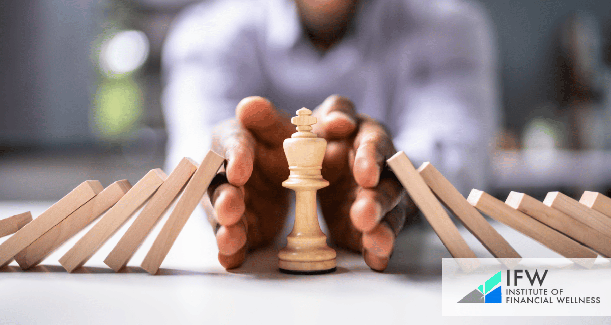 A man using his hands to protect a chess piece from falling dominoes