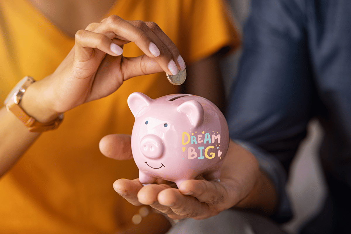 man and woman putting coins in a piggy bank 