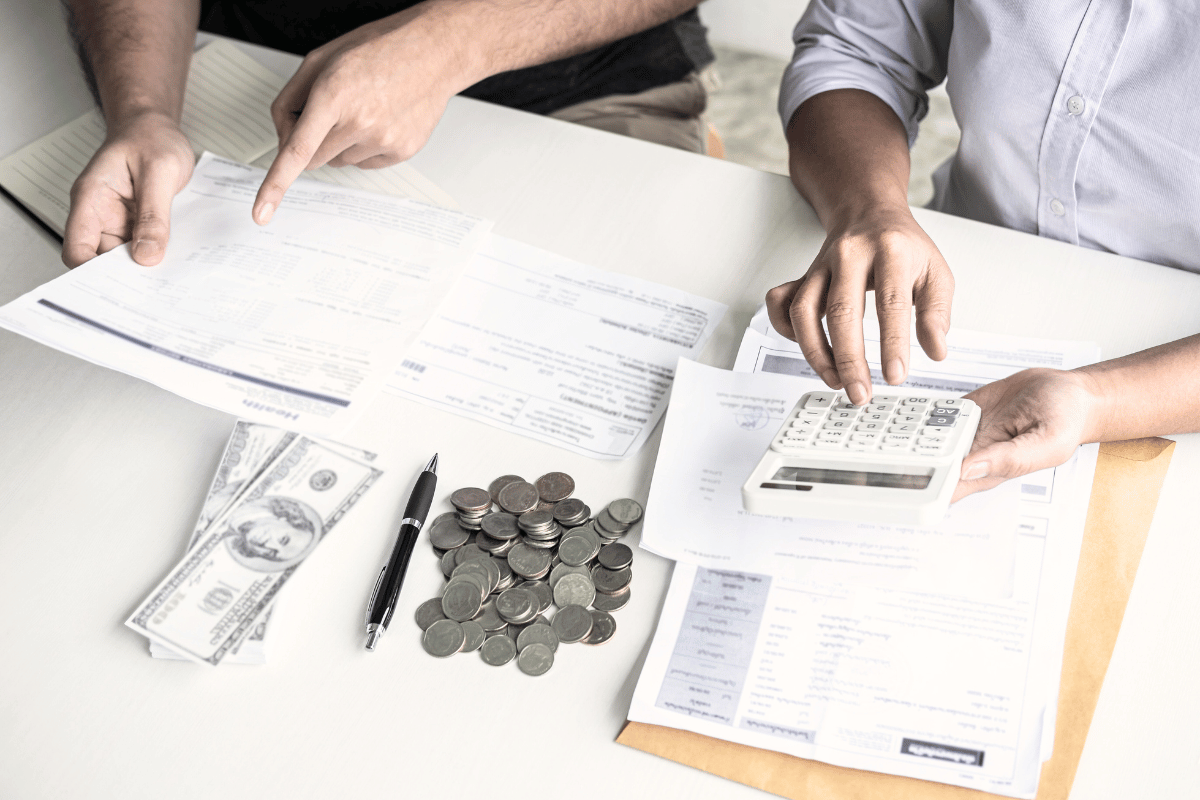 Couple reviewing their bills at a table and paying off their debts