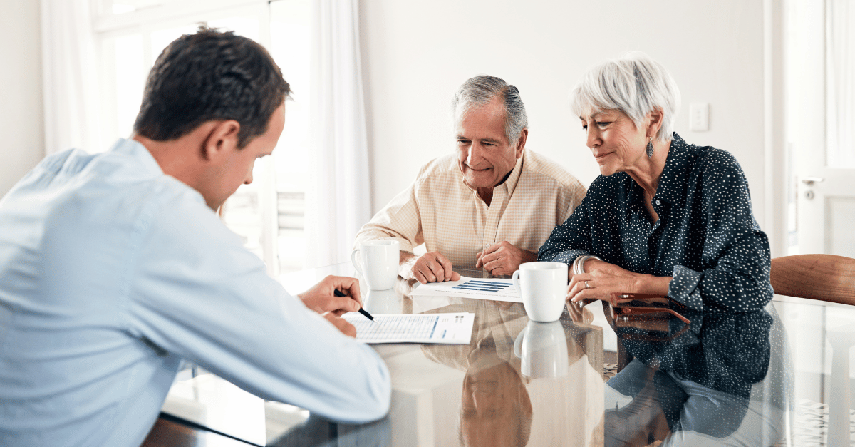 An elderly couple being talked to about retirement planning