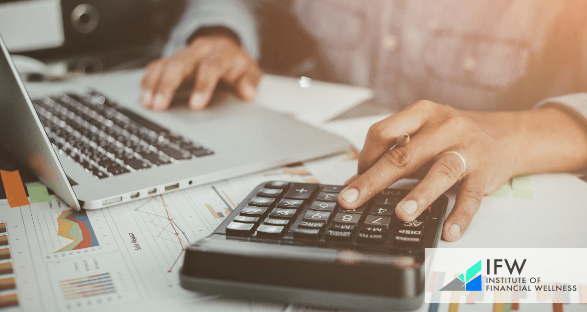 A person using a laptop and a calculator