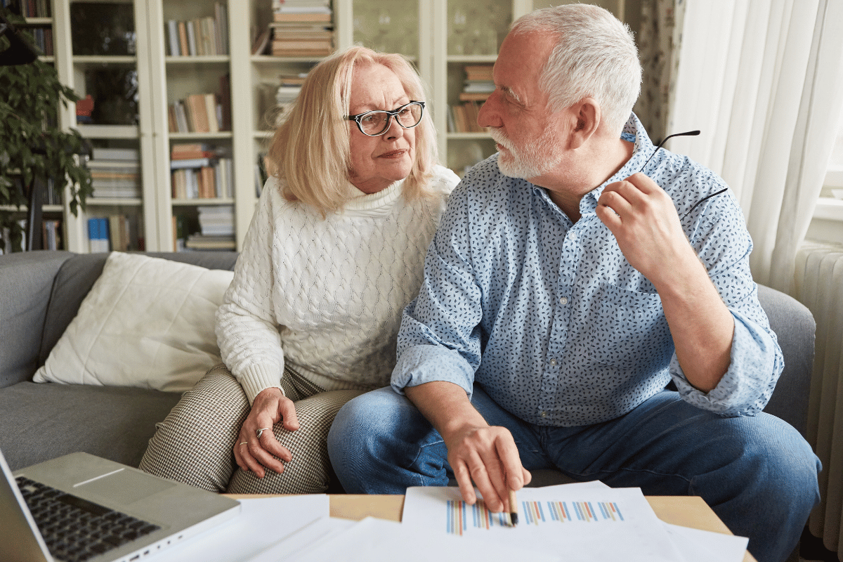 Elderly couple assessing their retirement needs with charts