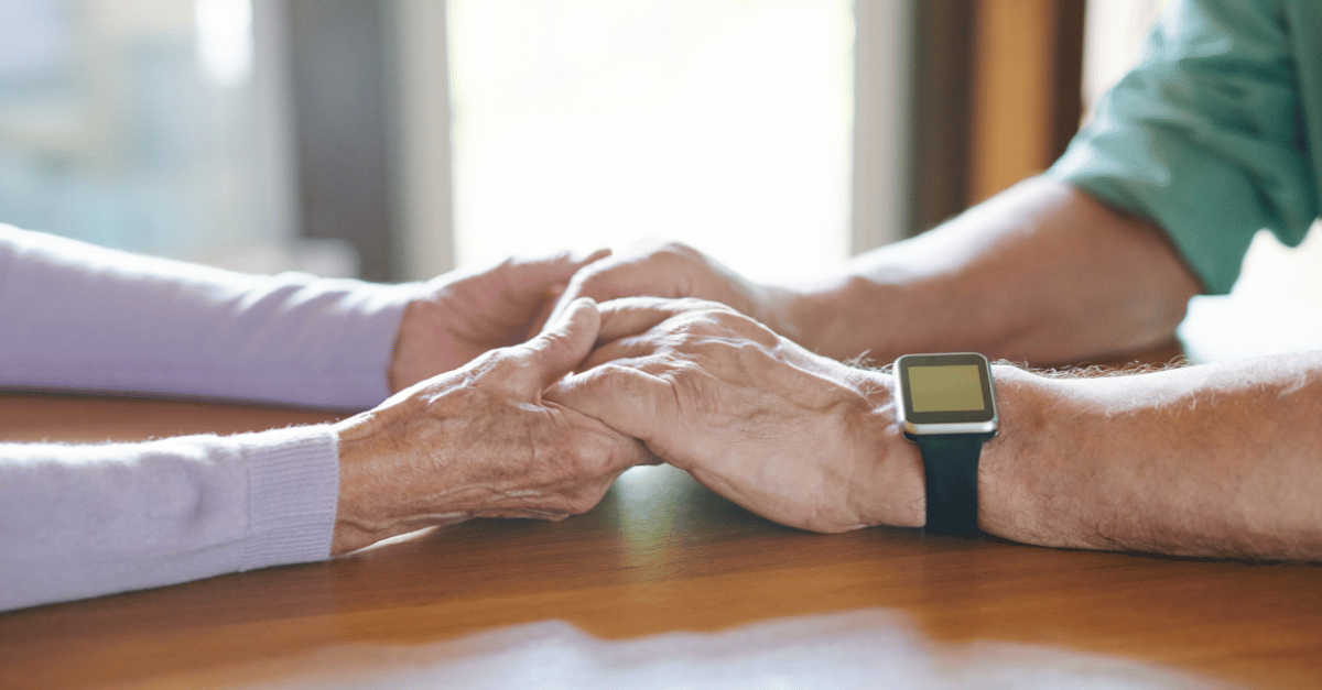 Elderly couple holding hands