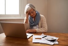 Senior woman, stress and laptop for bankruptcy in home, worry and paperwork for tax return or insurance. Elderly female person, frustrated and document for retirement plan, fail and mistake in budget