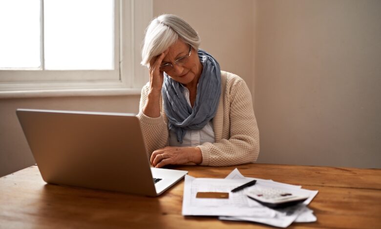 Senior woman, stress and laptop for bankruptcy in home, worry and paperwork for tax return or insurance. Elderly female person, frustrated and document for retirement plan, fail and mistake in budget