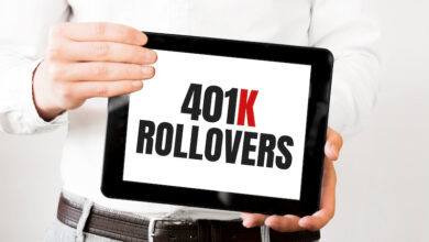 Text 401k ROLLOvERS on tablet display in businessman hands on the white bakcground. Business concept