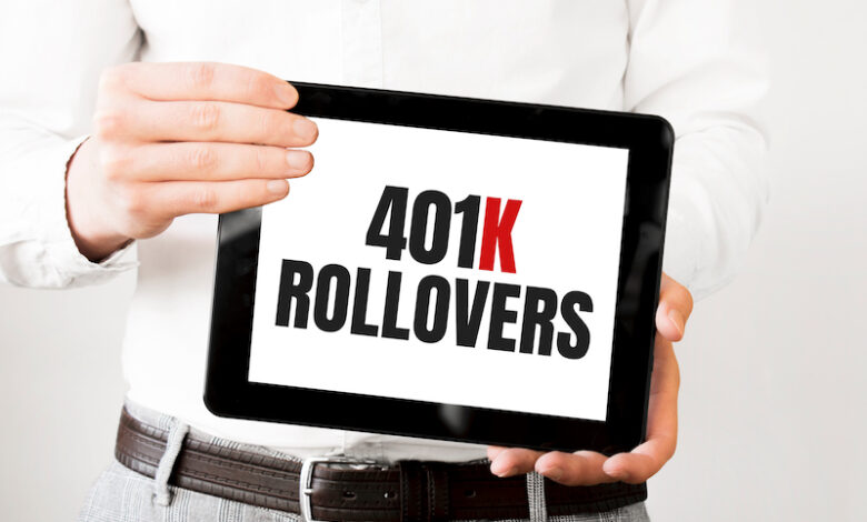 Text 401k ROLLOvERS on tablet display in businessman hands on the white bakcground. Business concept