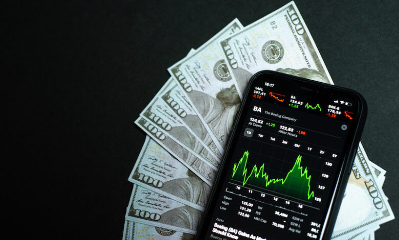 Samara Russia - 04.05.2020: Shares of a Boeing company on the screen of iPhone 11 against the backdrop of hundred-dollar bills. The fall and growth of stocks, the concept of a brokerage account