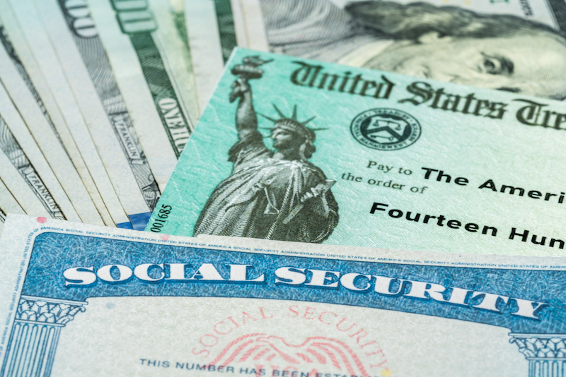 Stack of 100 dollar bills with US Treasury illustrative check to illustrate American Rescue Plan Act of 2021 payment with social security card for retirees