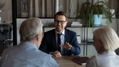 Happy confident lawyer, realtor, notary, financial advisor giving consultation, legal advice to senior couple of clients about medical insurance, wills, house buying or selling, savings, investment