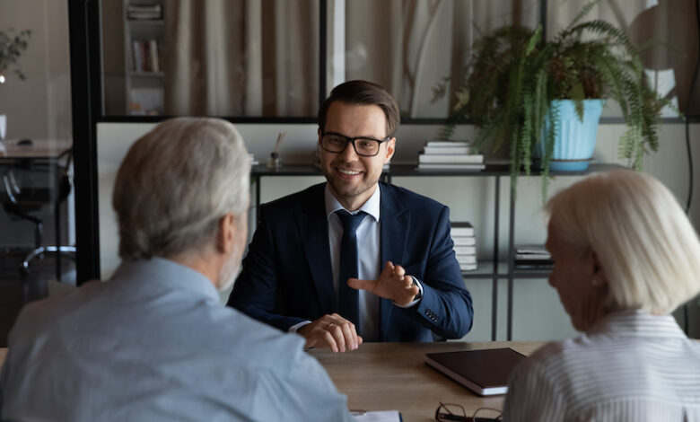 Happy confident lawyer, realtor, notary, financial advisor giving consultation, legal advice to senior couple of clients about medical insurance, wills, house buying or selling, savings, investment