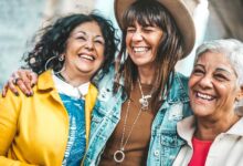 Three senior women having fun laughing out loud outside - Happy female friends talking together walking on city street - Life style concept with mature females hanging outdoors on summer holiday