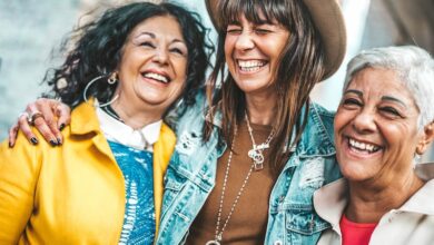 Three senior women having fun laughing out loud outside - Happy female friends talking together walking on city street - Life style concept with mature females hanging outdoors on summer holiday